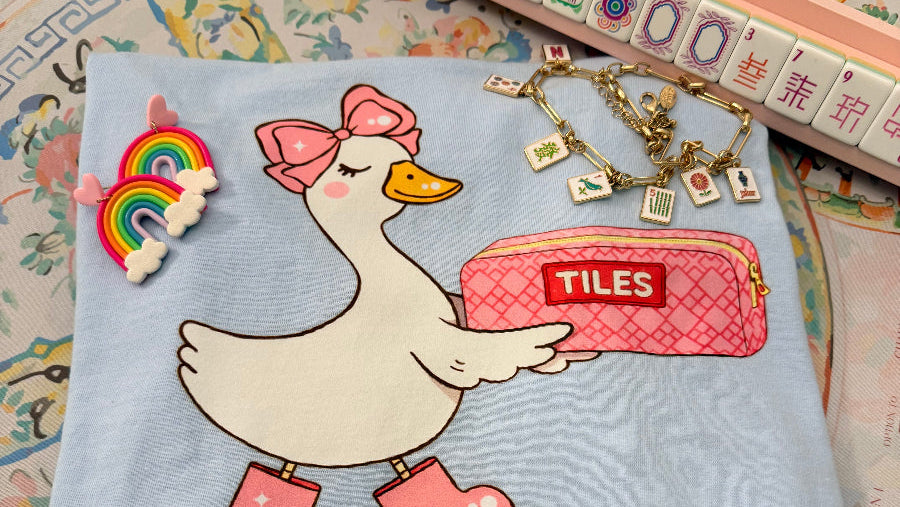 Towel with cartoon duck holding a bag labeled 'Tiles' and text 'One More Game' on a vintage-style background.